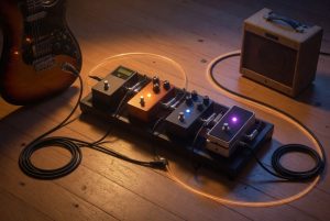 Beginner guitar pedalboard signal chain from electric guitar through tuner, overdrive, delay, and reverb into a small amp.